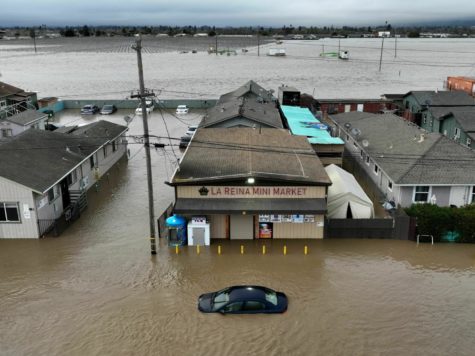 This aerial photograph shows a car and market shop in floodwaters in Pajaro, California on Saturday, March 11, 2023. - Residents were forced to evacuate in the middle of the night after an atmospheric river surge broke the the Pajaro Levee and sent flood waters flowing into the community. (Photo by JOSH EDELSON / AFP) (Photo by JOSH EDELSON/AFP via Getty Images)